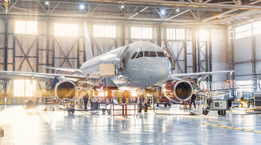 View inside the aviation hangar, the airplane mechanic working around the service